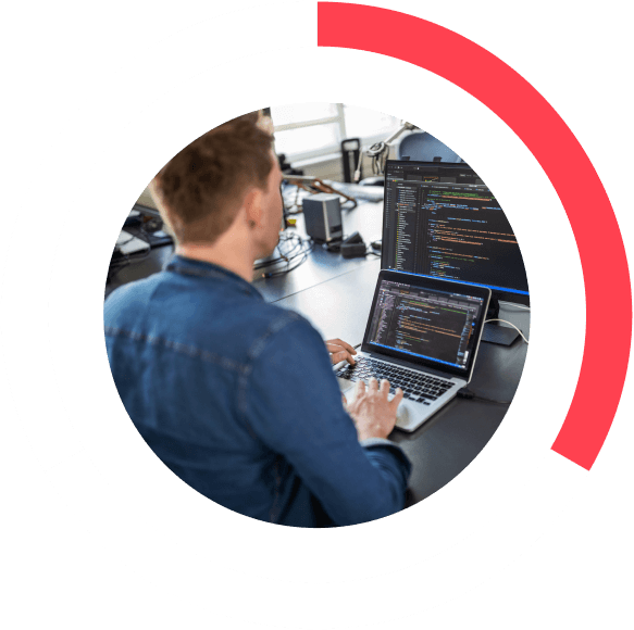 man coding on a laptop and computer